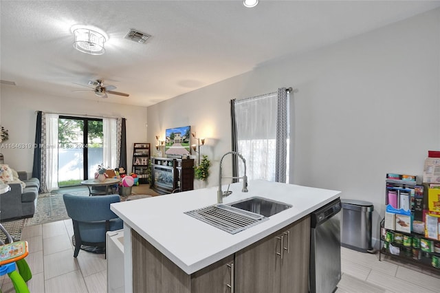 kitchen with a center island with sink, ceiling fan, sink, and light tile patterned floors