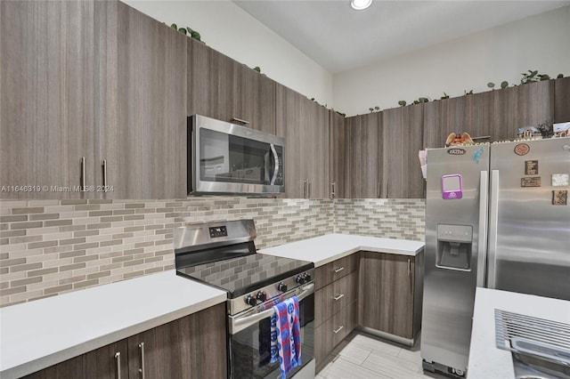 kitchen with backsplash, light tile patterned floors, stainless steel appliances, and dark brown cabinets