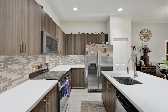 kitchen featuring backsplash, sink, light tile patterned floors, and appliances with stainless steel finishes