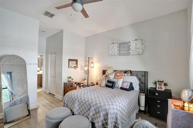 bedroom with light hardwood / wood-style flooring, ceiling fan, and connected bathroom