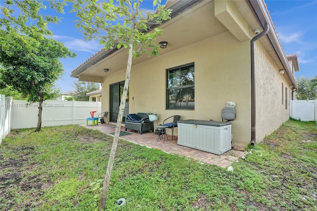 rear view of property with a yard and a patio