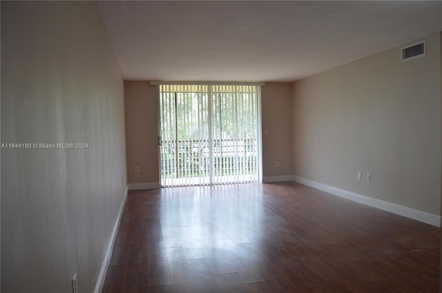 unfurnished room featuring hardwood / wood-style flooring and a wall of windows