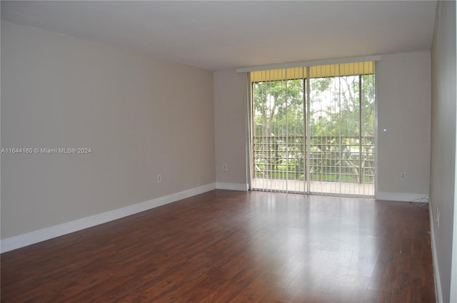 empty room featuring expansive windows and hardwood / wood-style floors