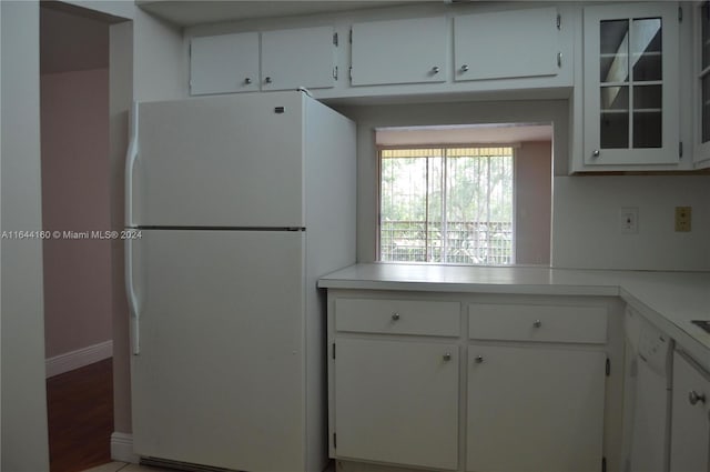 kitchen with white cabinetry, wood-type flooring, and white appliances