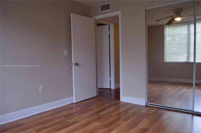 unfurnished bedroom with ceiling fan, hardwood / wood-style flooring, and a closet