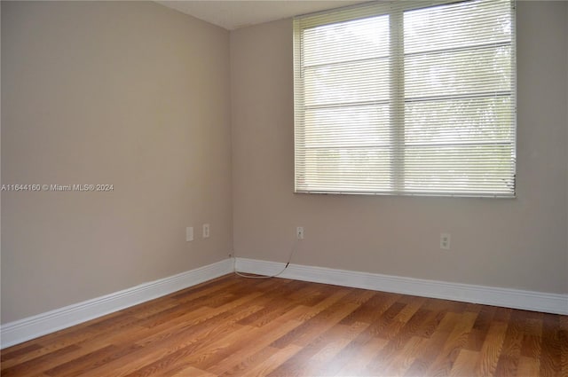 empty room with plenty of natural light and wood-type flooring