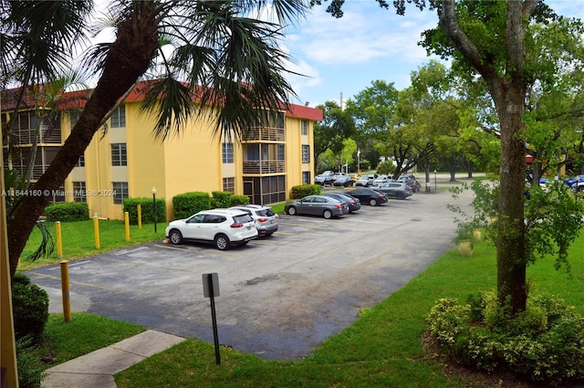 view of parking / parking lot featuring a yard