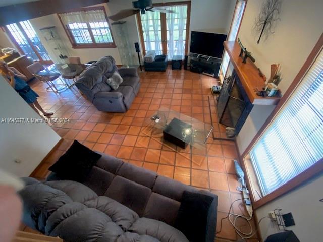 living room featuring tile patterned flooring, plenty of natural light, and ceiling fan