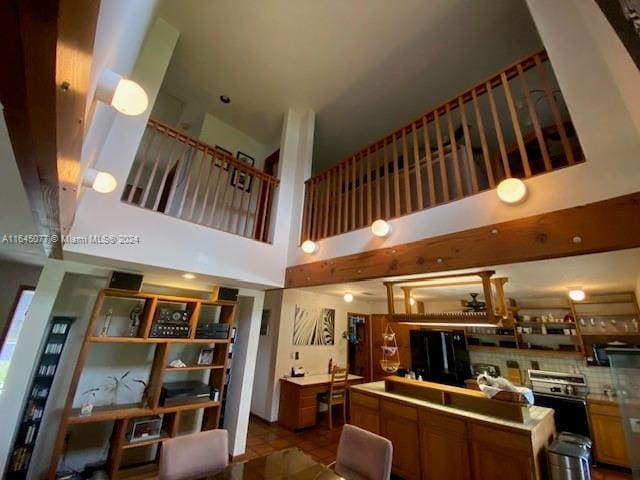 interior space featuring a high ceiling, light tile patterned floors, and refrigerator