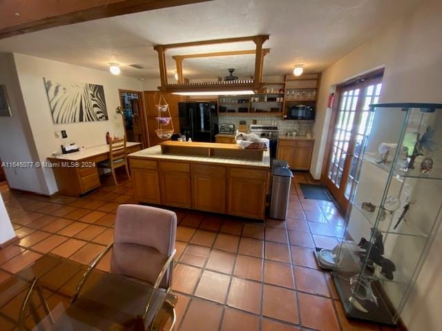 kitchen with tile countertops, decorative backsplash, light tile patterned floors, and black appliances