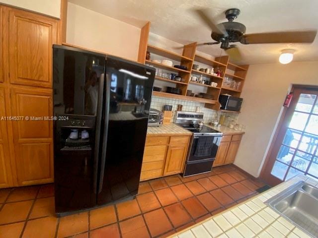 kitchen featuring ceiling fan, backsplash, electric stove, tile counters, and black fridge with ice dispenser