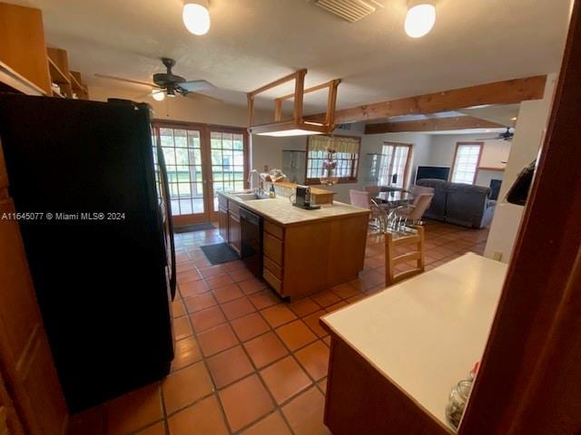 kitchen featuring ceiling fan, light tile patterned floors, sink, black appliances, and a center island