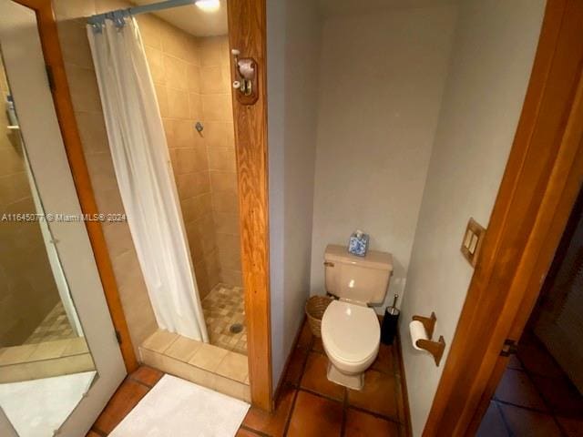 bathroom featuring tile patterned floors, toilet, and a shower with curtain