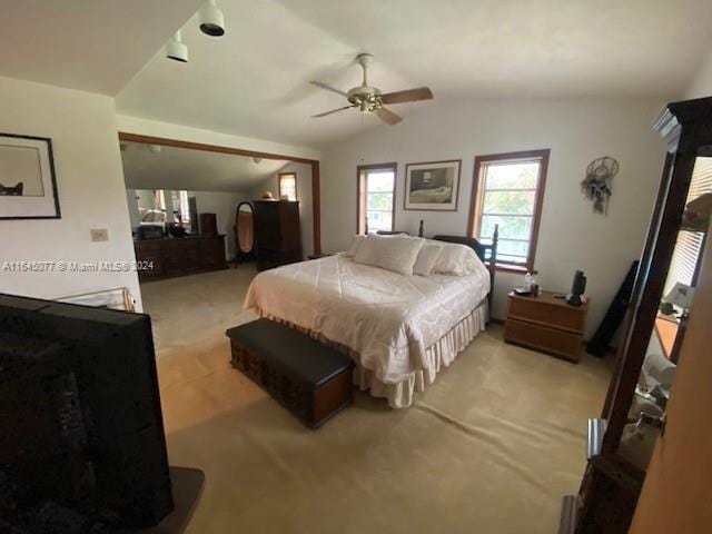 bedroom featuring light colored carpet, vaulted ceiling, and ceiling fan