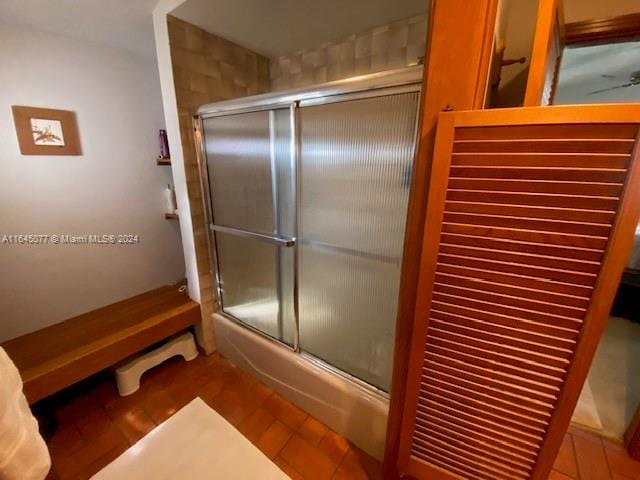 bathroom featuring tile patterned floors and bath / shower combo with glass door