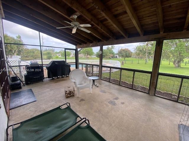 unfurnished sunroom with ceiling fan and vaulted ceiling