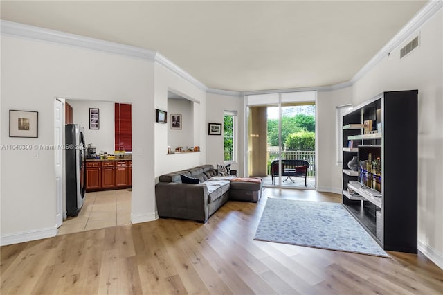 living room with ornamental molding and light tile patterned floors