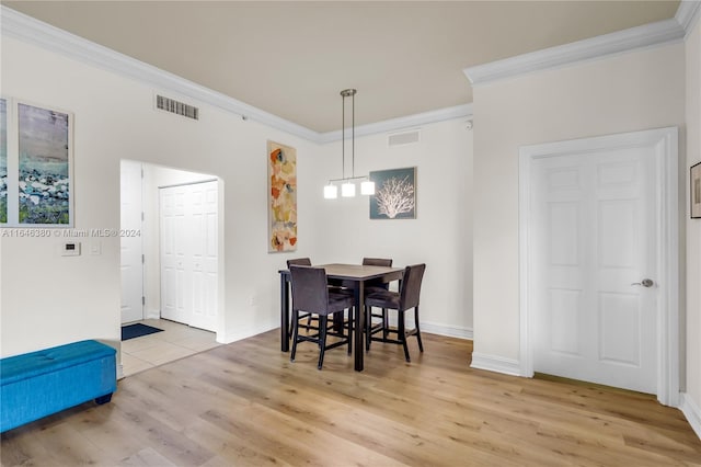 dining space featuring crown molding and light hardwood / wood-style floors