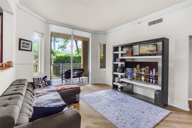 living room featuring crown molding and light hardwood / wood-style floors