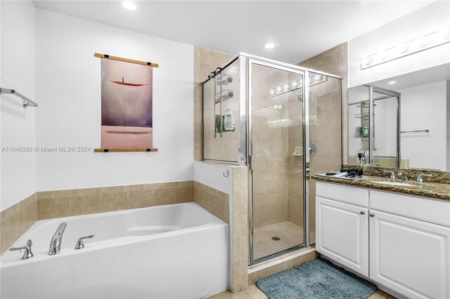 bathroom with tile patterned floors, shower with separate bathtub, and vanity