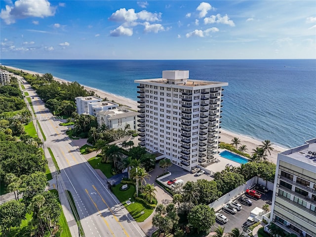 birds eye view of property with a water view and a beach view