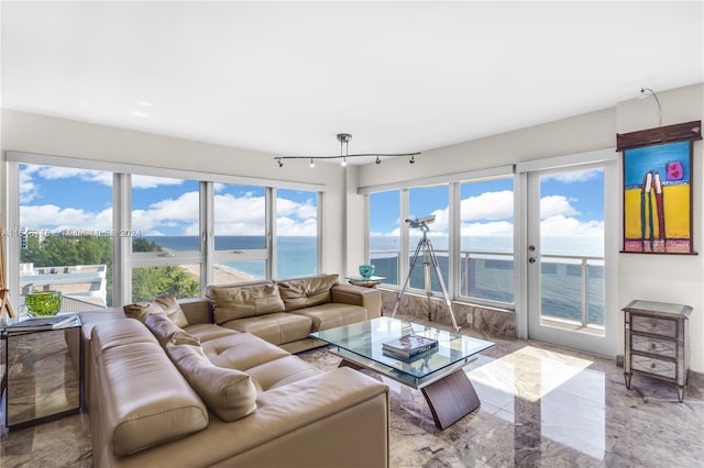 living room with marble finish floor, a water view, and track lighting