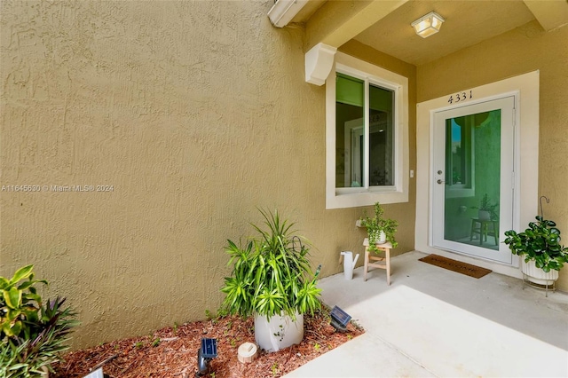 property entrance with a patio area and stucco siding