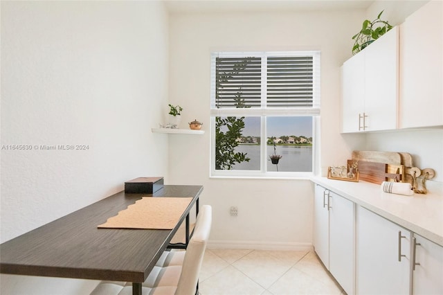 interior space featuring baseboards and light tile patterned flooring