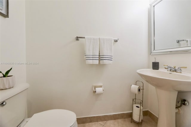 bathroom with tile patterned flooring, baseboards, and toilet