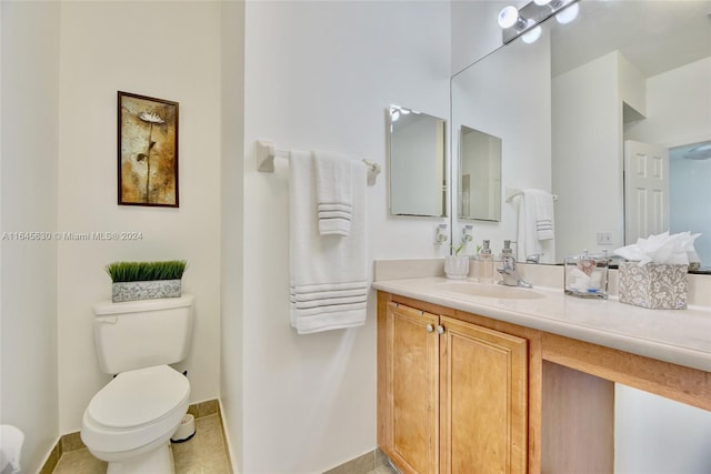 bathroom featuring baseboards, vanity, and toilet