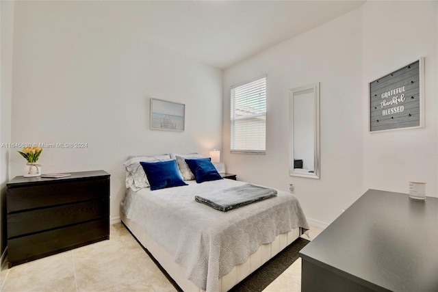 bedroom with light tile patterned flooring and baseboards