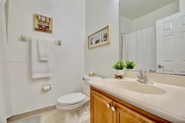 bathroom featuring tile patterned flooring, baseboards, vanity, and toilet