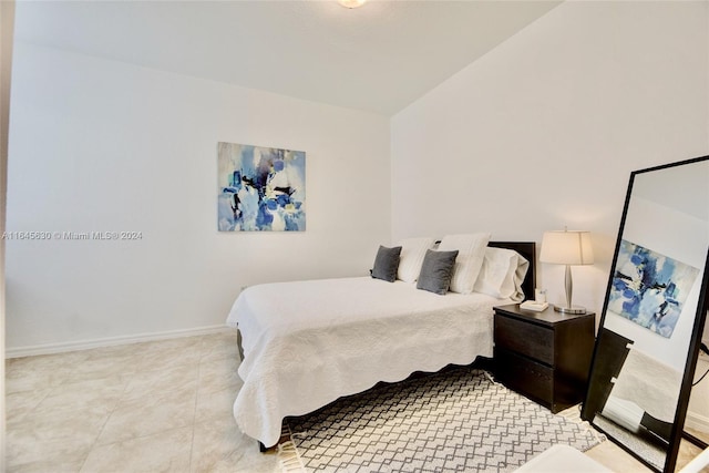 bedroom with light tile patterned flooring and baseboards