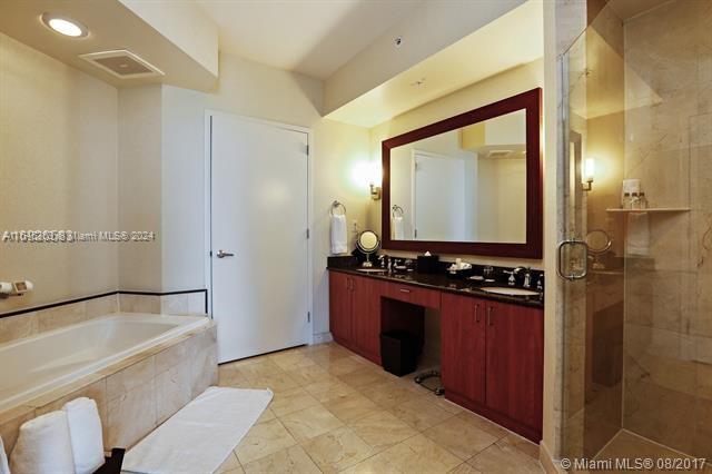 bathroom featuring tile patterned flooring, vanity, and independent shower and bath