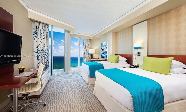 carpeted bedroom featuring ornamental molding, a water view, access to outside, expansive windows, and a textured ceiling