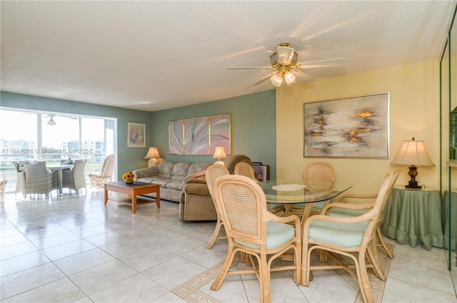 tiled dining room with ceiling fan and a textured ceiling