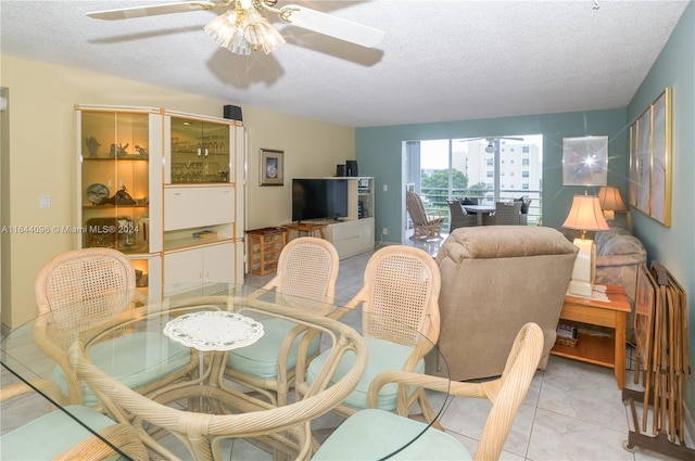 dining room featuring ceiling fan, light tile patterned floors, and a textured ceiling