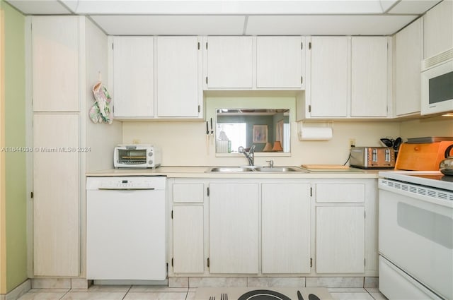 kitchen with sink, white cabinets, white appliances, and light tile patterned floors