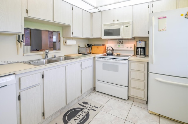 kitchen featuring sink, white appliances, white cabinets, and light tile patterned floors