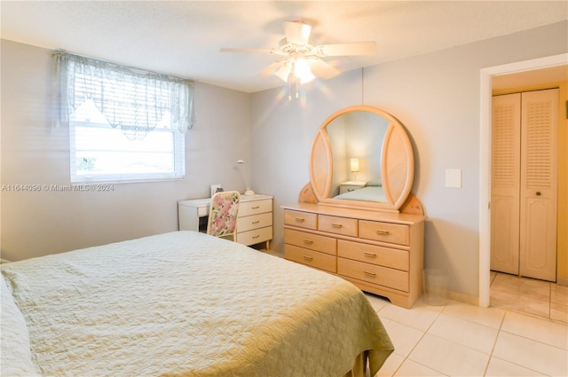 bedroom featuring ceiling fan, a closet, and light tile patterned flooring