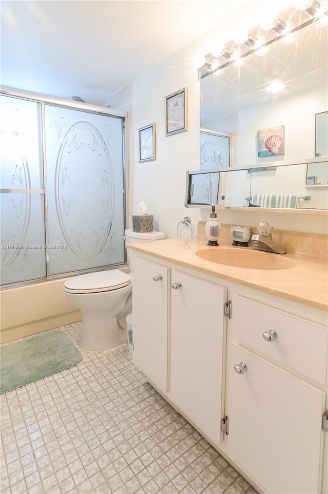 full bathroom with tile patterned flooring, toilet, vanity, and combined bath / shower with glass door