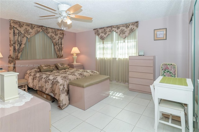 tiled bedroom featuring a textured ceiling and ceiling fan