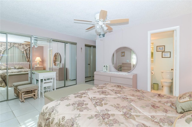 tiled bedroom with ceiling fan, two closets, and a textured ceiling