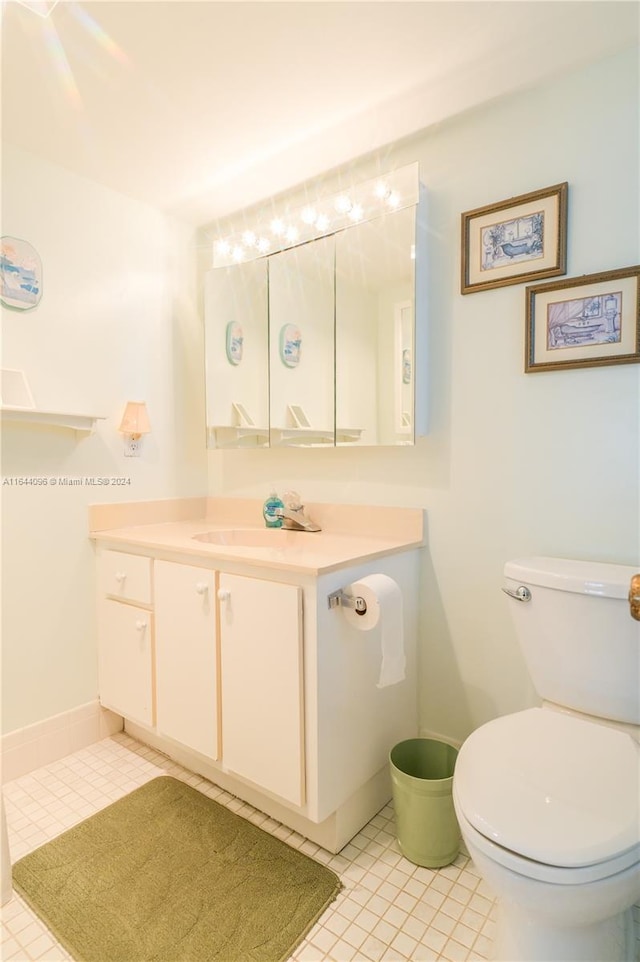 bathroom with toilet, tile patterned floors, and vanity