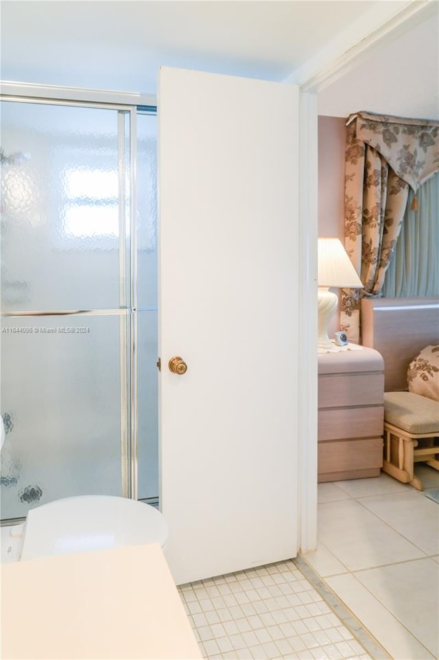 bathroom with tile patterned flooring, a shower with door, and vanity