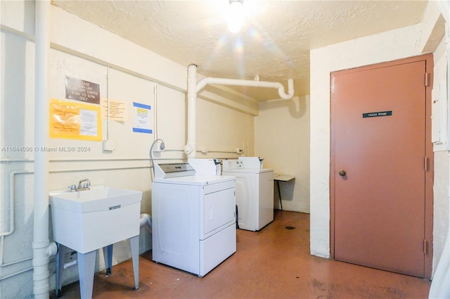 clothes washing area with washer and dryer and sink