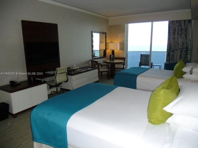 bedroom featuring carpet and a water view