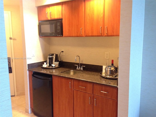 kitchen featuring sink, light tile patterned flooring, black appliances, and dark stone counters