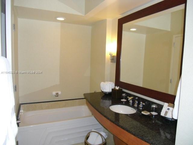 bathroom featuring sink and a tub to relax in