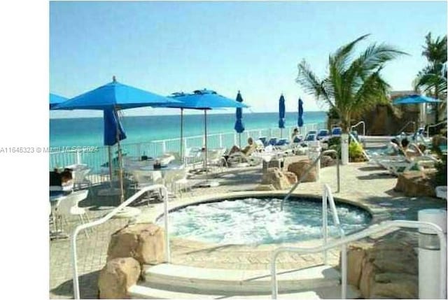 view of swimming pool with a community hot tub and a water view